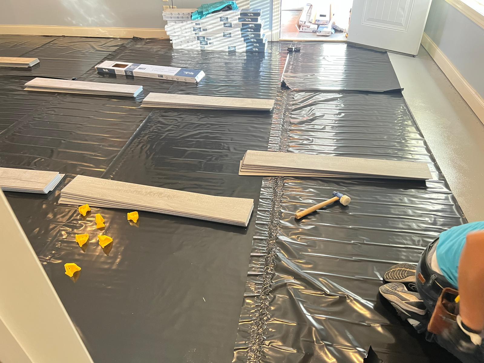 Floating floor installation in progress over an underlayment